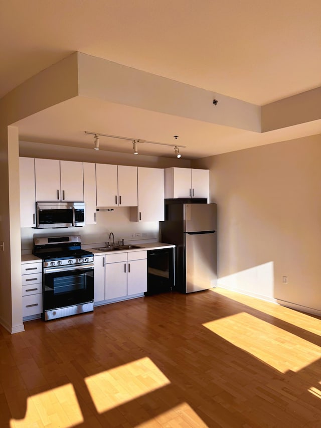 kitchen featuring appliances with stainless steel finishes, wood finished floors, and white cabinetry