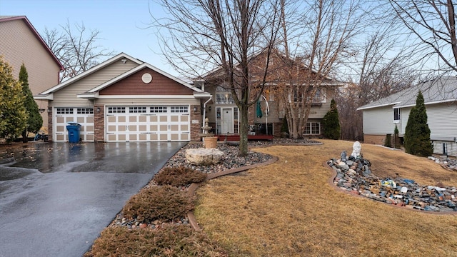 view of front of home featuring stone siding, a front lawn, an attached garage, and driveway