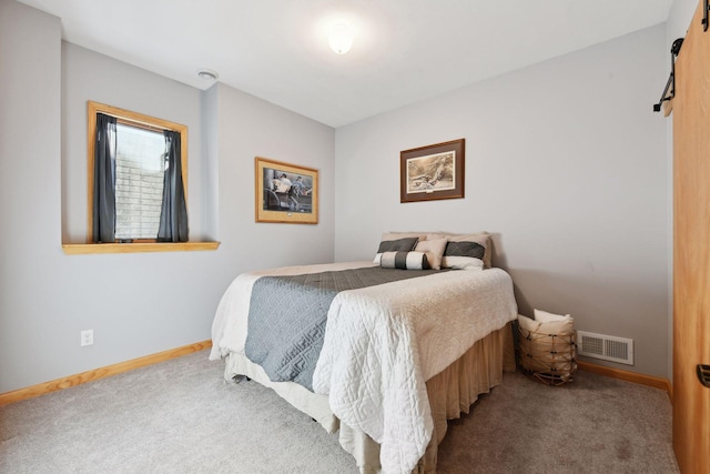 bedroom featuring carpet flooring and a barn door