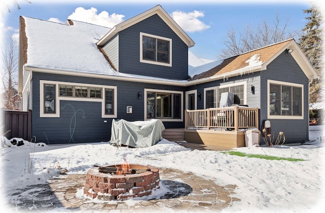 snow covered property with a deck and an outdoor fire pit