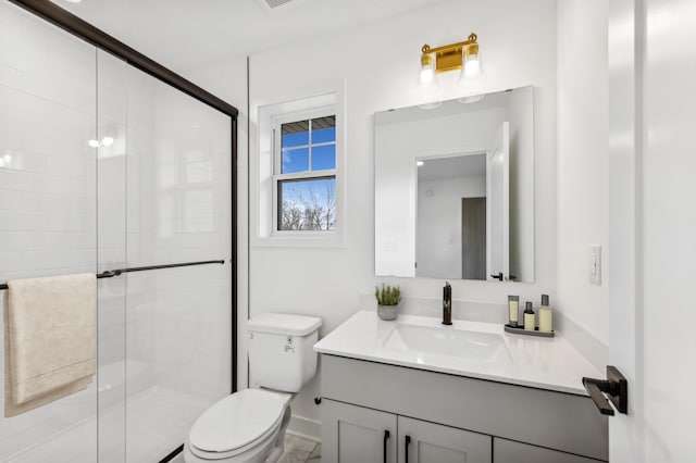 bathroom with toilet, a stall shower, and vanity