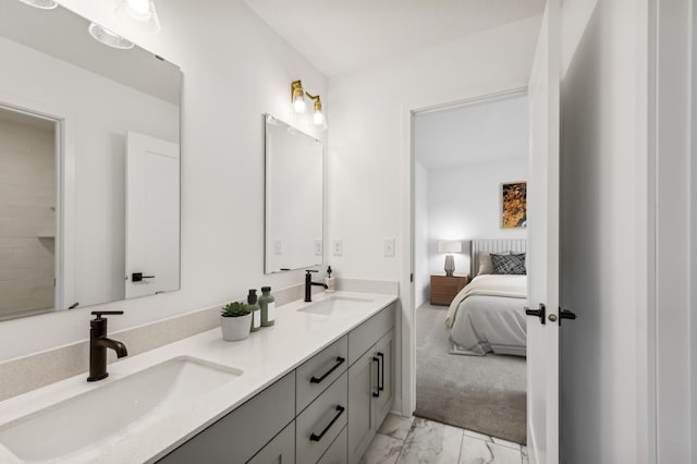 ensuite bathroom with ensuite bathroom, marble finish floor, double vanity, and a sink