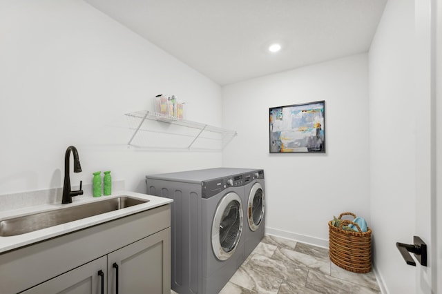 clothes washing area featuring marble finish floor, washing machine and clothes dryer, cabinet space, a sink, and baseboards