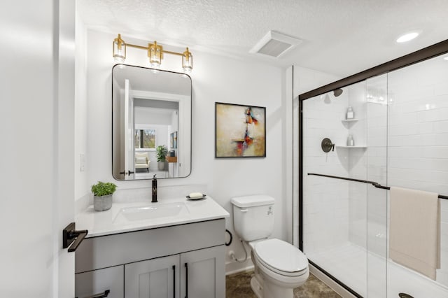 bathroom with visible vents, toilet, a stall shower, a textured ceiling, and vanity