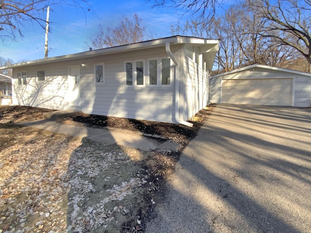 view of home's exterior with a garage and an outbuilding