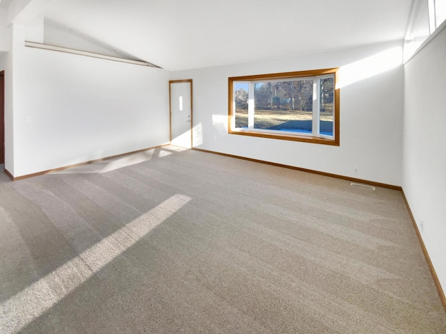 carpeted spare room with lofted ceiling