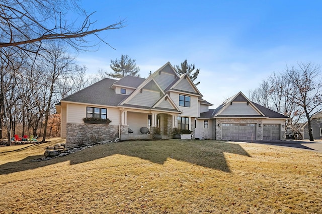 craftsman-style home featuring a garage, stone siding, and a front yard