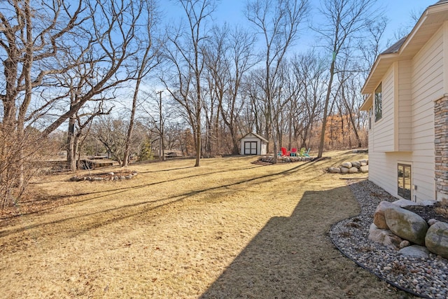 view of yard featuring a storage unit and an outbuilding