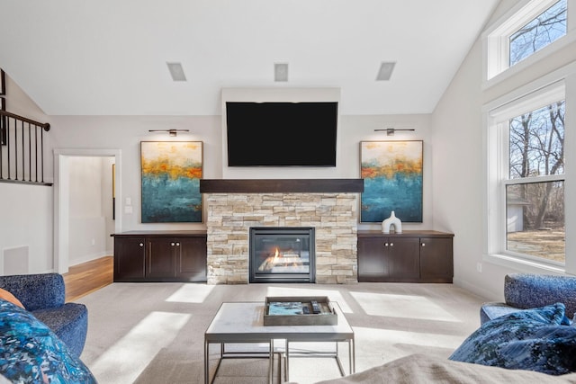 living area with carpet floors, lofted ceiling, a fireplace, and baseboards