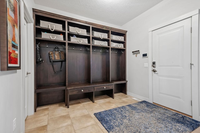 mudroom featuring a textured ceiling and baseboards