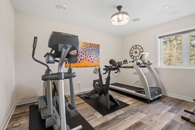 workout room with baseboards and wood finished floors