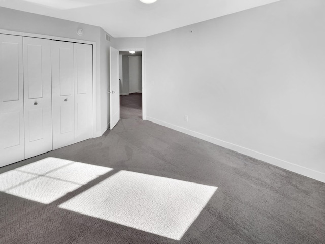 unfurnished bedroom with a closet and dark carpet