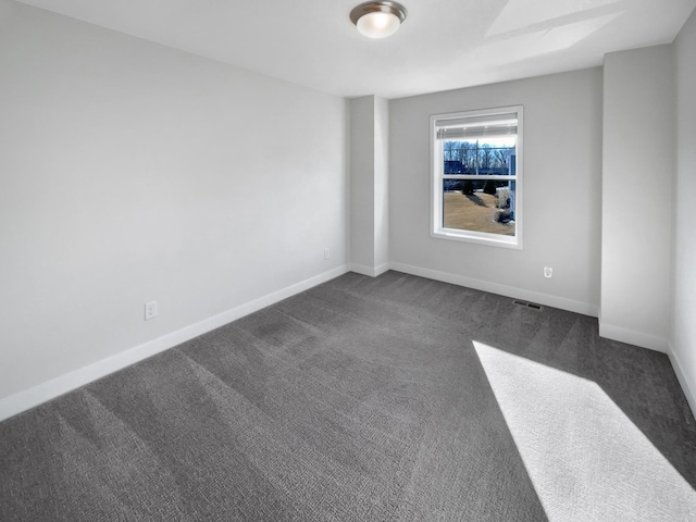 unfurnished room featuring dark colored carpet