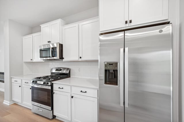 kitchen featuring decorative backsplash, light wood-style flooring, stainless steel appliances, light countertops, and white cabinetry