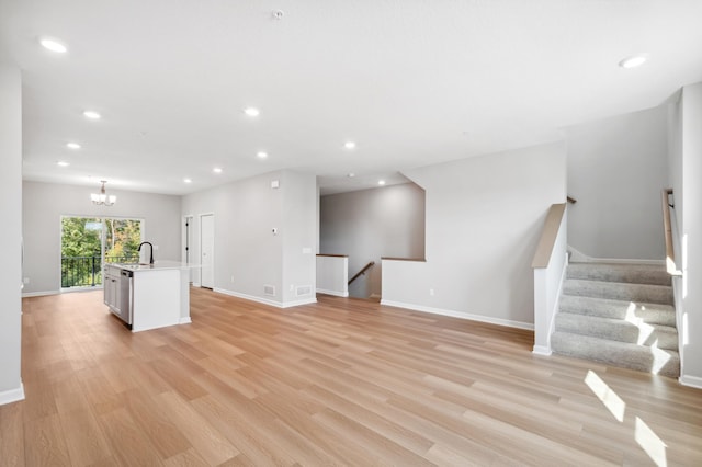 unfurnished living room featuring light wood-style floors, recessed lighting, and a sink