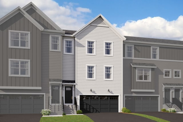 townhome / multi-family property with driveway, an attached garage, and board and batten siding