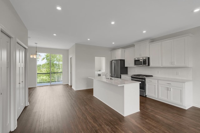 kitchen featuring stainless steel appliances, a sink, white cabinetry, light countertops, and tasteful backsplash