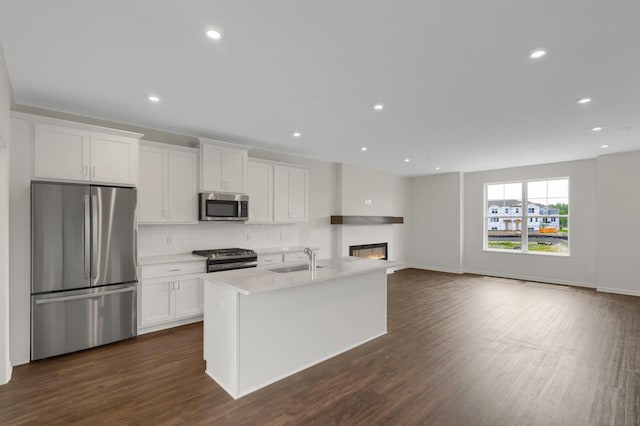 kitchen featuring dark wood-style floors, white cabinetry, stainless steel appliances, and a sink