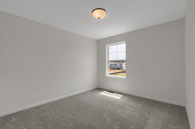 carpeted spare room with baseboards