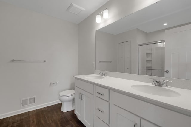 full bathroom with visible vents, a sink, toilet, and wood finished floors