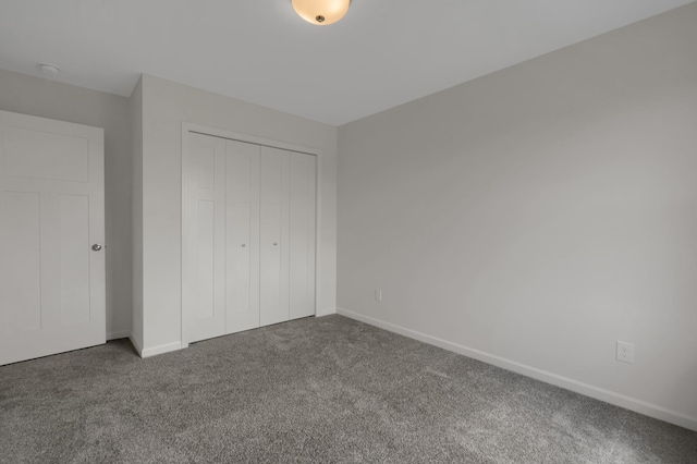 unfurnished bedroom with a closet, carpet, and baseboards