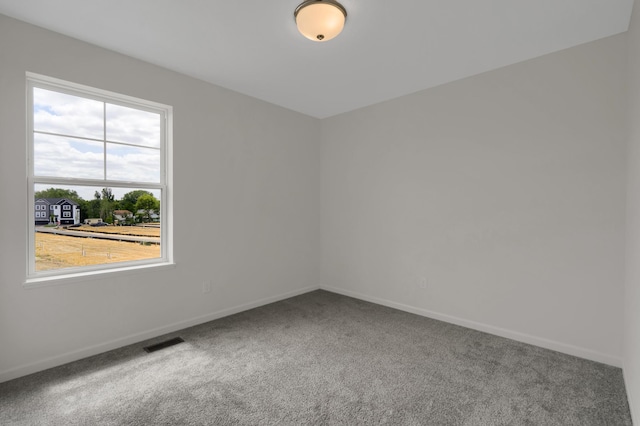 carpeted empty room with visible vents and baseboards