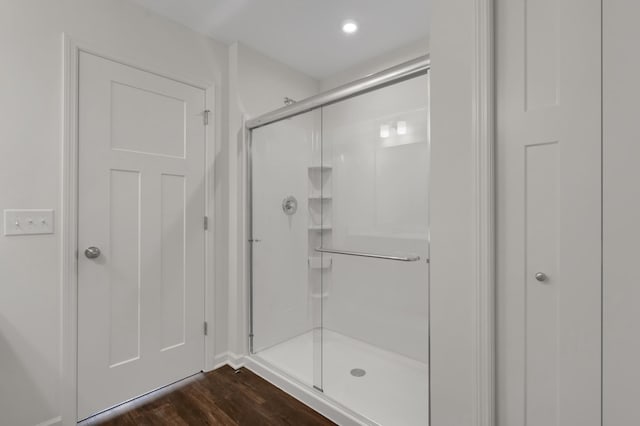 full bath featuring a shower stall and wood finished floors