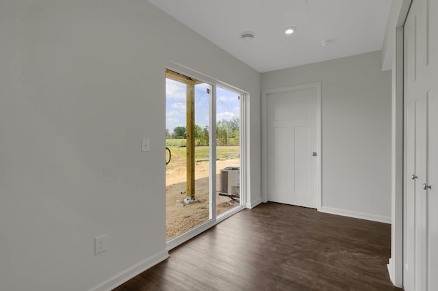 spare room with dark wood-style floors, recessed lighting, and baseboards