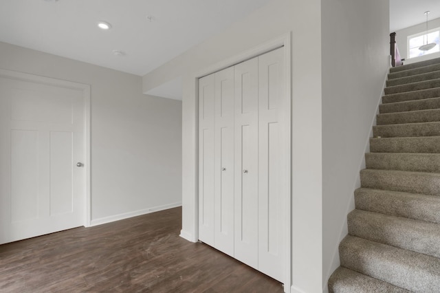 stairway with baseboards, wood finished floors, and recessed lighting