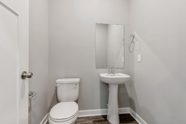 bathroom featuring hardwood / wood-style flooring, sink, and toilet