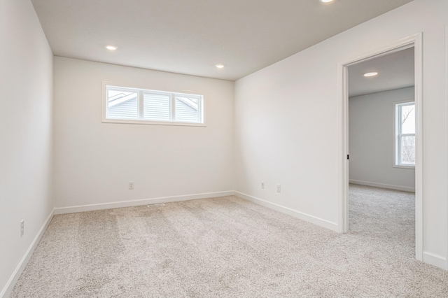 spare room with light carpet, baseboards, and recessed lighting