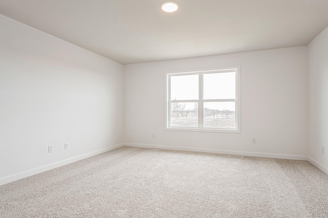 unfurnished room featuring carpet and baseboards