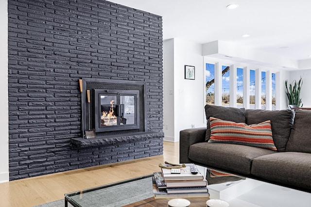 living room featuring recessed lighting, a fireplace, baseboards, and wood finished floors