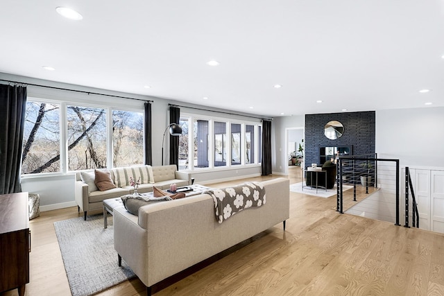 living area featuring baseboards, recessed lighting, a wealth of natural light, and light wood-style floors