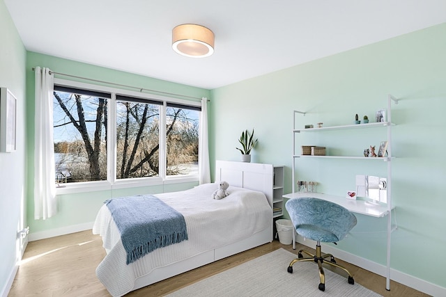 bedroom with baseboards and wood finished floors