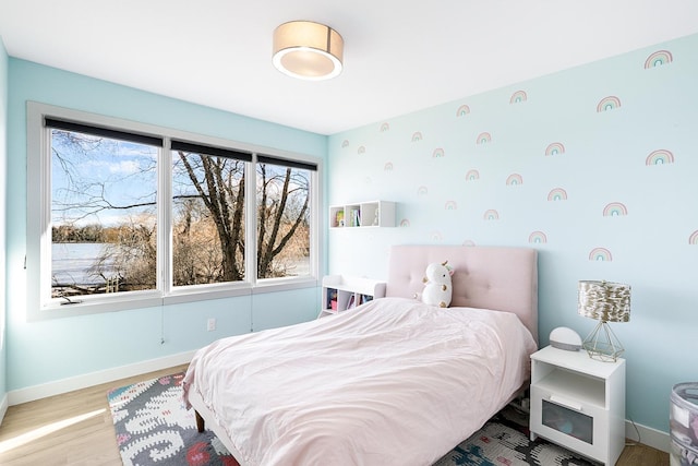 bedroom with baseboards and wood finished floors