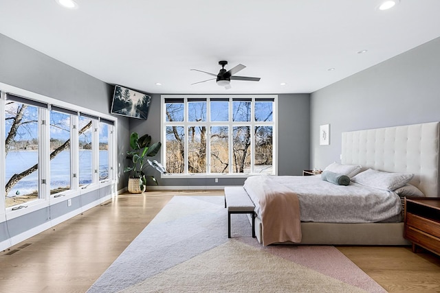 bedroom featuring baseboards, wood finished floors, visible vents, and recessed lighting