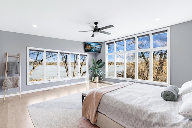 bedroom featuring baseboards, multiple windows, wood finished floors, and recessed lighting