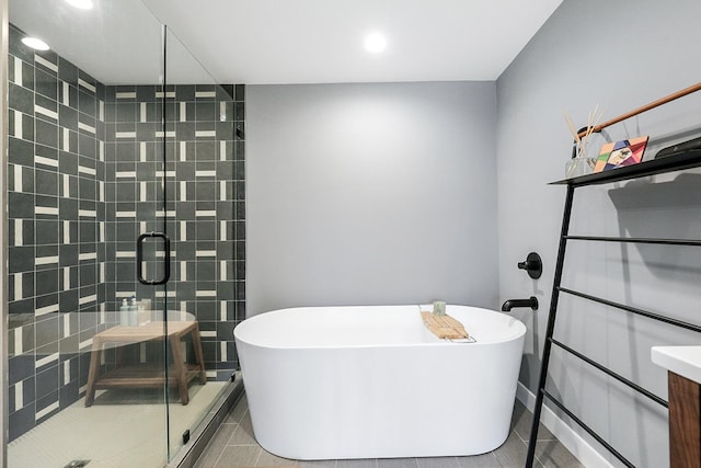 full bath featuring a soaking tub, a shower stall, vanity, and tile patterned floors