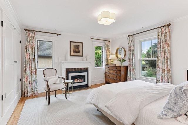 4943 Dupont Ave S, Minneapolis, MN 55419 - bedroom with ornamental molding, multiple windows, a fireplace with flush hearth, and light wood-style floors