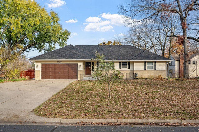 ranch-style house with a garage, brick siding, driveway, and fence