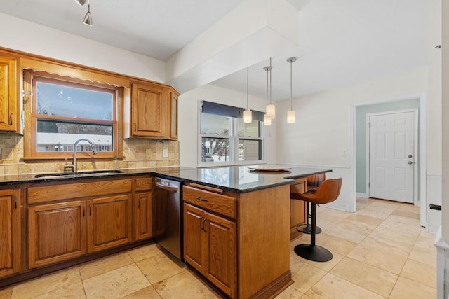 kitchen featuring brown cabinets, dishwasher, a peninsula, and a sink