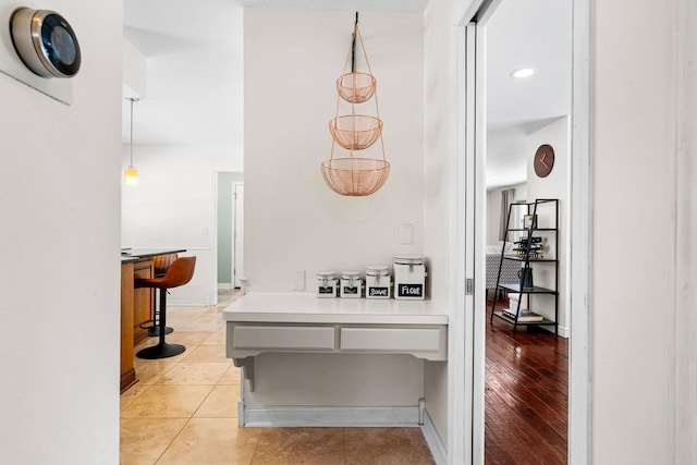 hallway with light tile patterned floors and baseboards