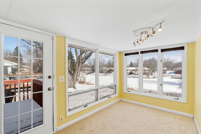 unfurnished sunroom featuring a healthy amount of sunlight and rail lighting