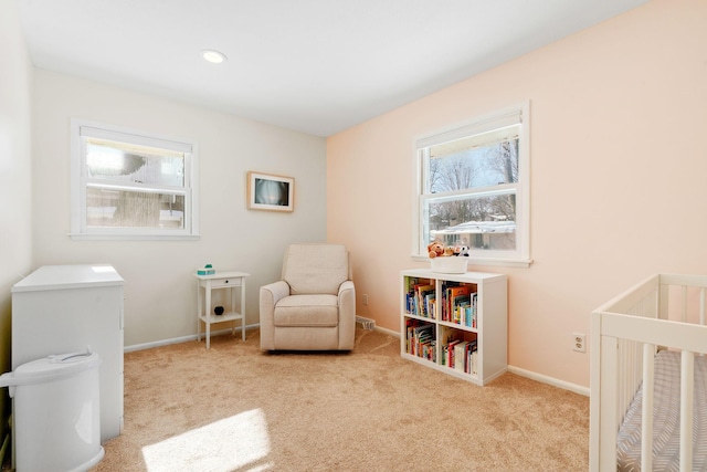 carpeted bedroom featuring baseboards and a nursery area