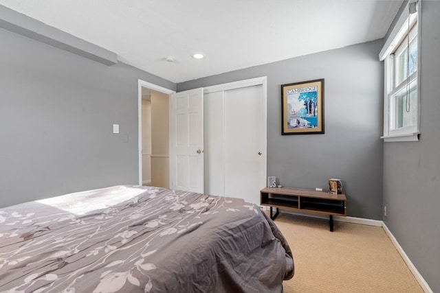 carpeted bedroom featuring a closet, recessed lighting, and baseboards