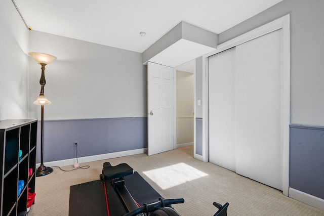 exercise room with baseboards and carpet