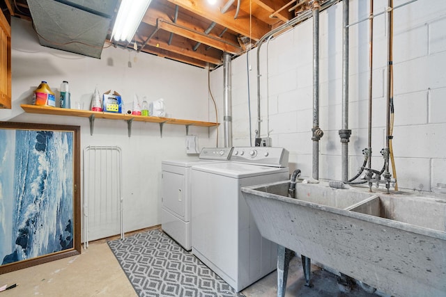 laundry area with concrete block wall, washing machine and dryer, and laundry area