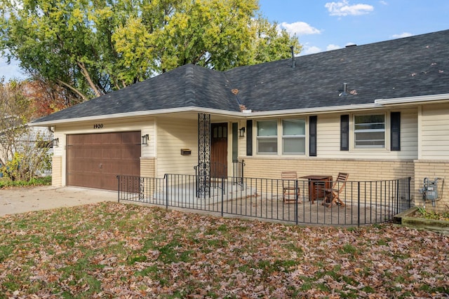 ranch-style house with driveway, a garage, brick siding, and roof with shingles