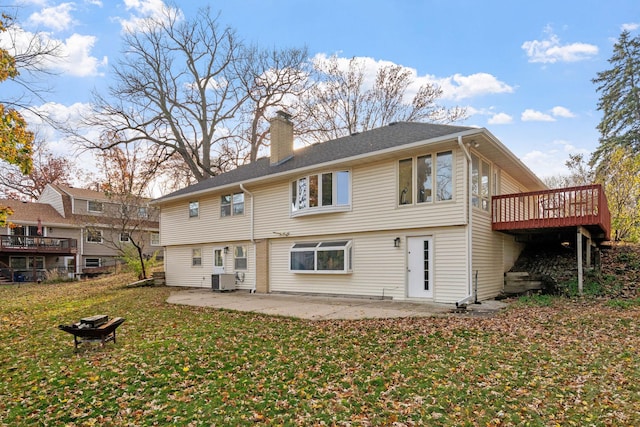 rear view of property featuring a patio, central AC unit, a chimney, a deck, and a lawn